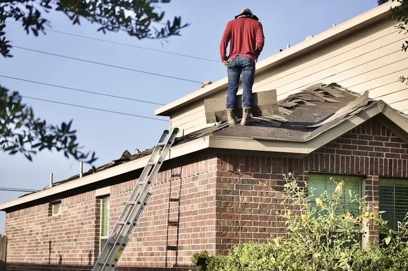 Professional roofer working on a residential roof in Higginsville